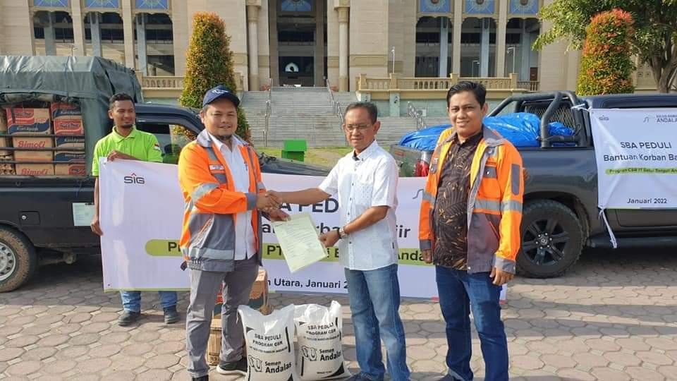 General Affair & Community Relation Manager SBA, Tafaul Rijal dan tim Packing Plant Lhokseumawe menyerahkan bantuan tanggap bencana banjir Aceh Utara kepada Kepala BPBD Kab. Aceh Utara, Asnawi di gudang BPBD Kab. Aceh Utara Ladeng, 8 Januari 2022